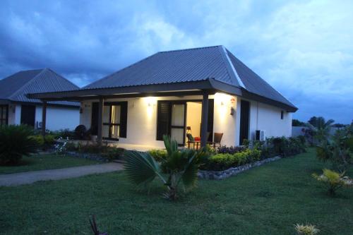 a small white house with a dark roof at Lander's Bay Resort in Lautoka