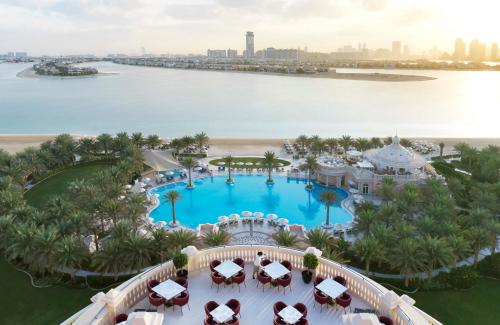 a beach scene with a large pool of water at Raffles The Palm in Dubai