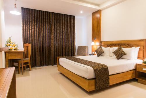a hotel room with a bed and a desk at The Hotel Canoe in Kannur