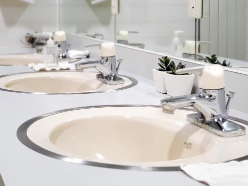 łazienka z 2 umywalkami i lustrem w obiekcie Pension Gooseberry w mieście Furano