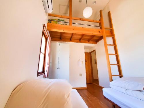 sypialnia z łóżkiem piętrowym i drabiną w obiekcie Pension Gooseberry w mieście Furano