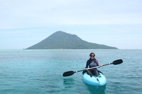 a woman is in a kayak in the water at Murex Dive Resort in Manado