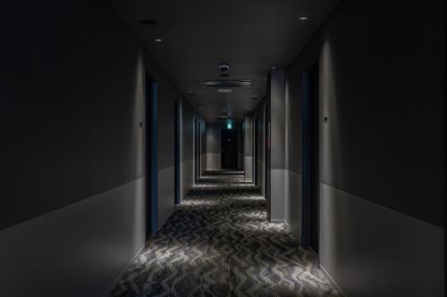 an empty corridor with black walls and a long hallway at UNO HOTEL in Tamano