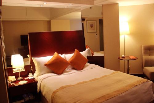 Uma cama ou camas num quarto em Merry Hotel Shanghai (Former Rendezvous Merry Hotel Shanghai)