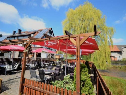 バート・ゾーデン・ザルミュンスターにあるLandgasthof Zum Jossatalのテーブル、椅子、パラソルが備わるレストラン
