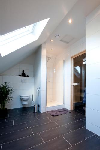a bathroom with a toilet and a walk in shower at B&B De Drentse Es in Emmen