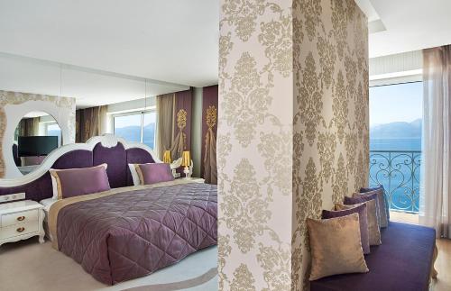 een slaapkamer met een paars bed en een groot raam bij La Boutique Hotel & Suites - Adults Only in Antalya