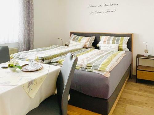 a bedroom with two beds and a table with at Landgasthof Zum Jossatal in Bad Soden-Salmünster