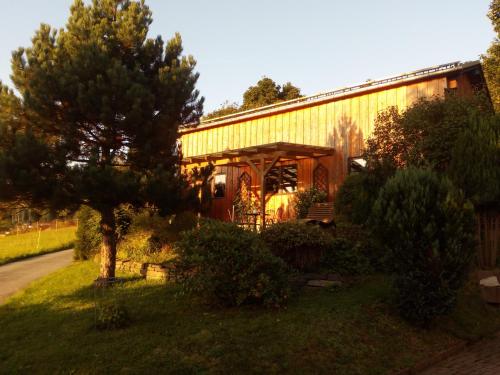 a building with a tree in front of it at Ferienwohnung Körnerberg in Klingenthal