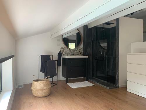 La salle de bains est pourvue d'une commode noire et d'un miroir. dans l'établissement Magnifique Villa classée 4* meublé de tourisme, à Flassans-sur-Issole