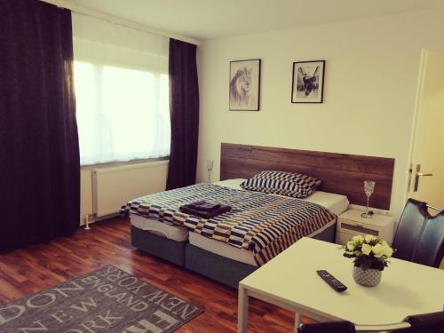 Schlafzimmer mit einem Bett, einem Tisch und einem Fenster in der Unterkunft MyCrib in Graz