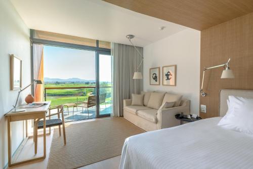 a hotel room with a bed and a couch at Empordà Golf Resort in Torroella de Montgrí