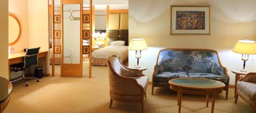 um quarto de hotel com uma cama e uma sala de estar em New World Shunde Hotel em Shunde