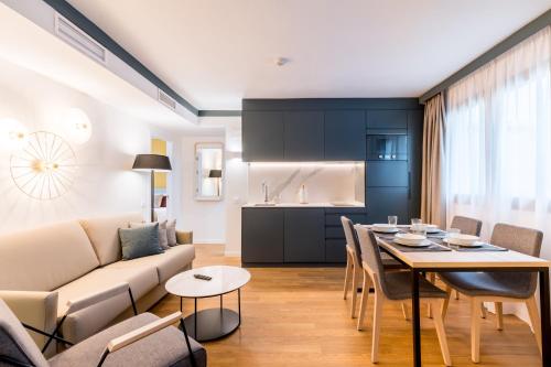 sala de estar y cocina con sofá y mesa en atLumbreras16 en Sevilla