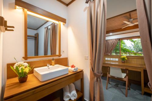 a bathroom with a sink and a mirror at Murex Bangka Dive Resort in Likupang