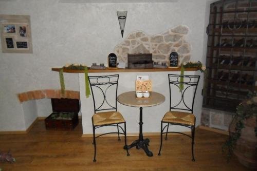 a table and two chairs in a room with a counter at Penzion Mnich in Nová Bystřice