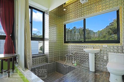 baño con aseo y lavabo y ventana en Mao Lan Mountain Holiday Villa, en Shan-tzu-chiao