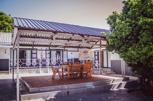 a wooden table and chairs under a pergola at The Daughters Guest House in Bethlehem