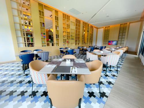 a dining room with tables and chairs in a restaurant at Mercure Kuala Lumpur Glenmarie in Shah Alam