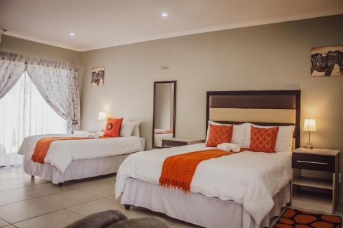 a hotel room with two beds and a window at The Daughters Guest House in Bethlehem