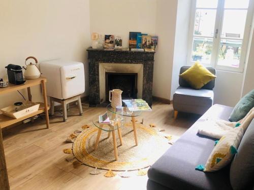 a living room with a couch and a fireplace at Hôtes de Maïa Chambre d'hôtes chez l'habitant in Moret-sur-Loing