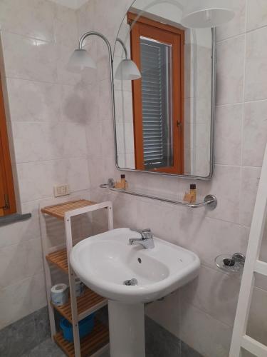 a bathroom with a white sink and a mirror at La dimora felice in Marmi