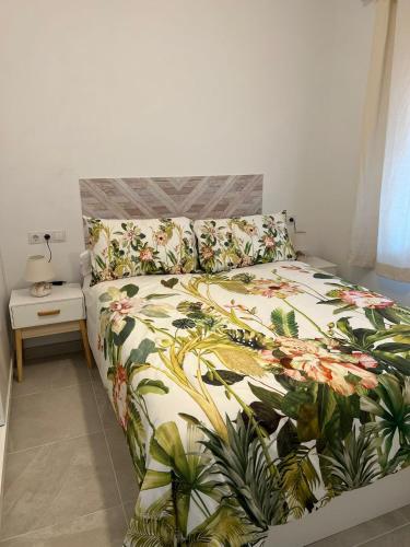 a bedroom with a bed with a floral bedspread at Fuengirola Center in Fuengirola