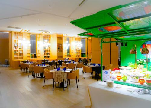 a restaurant with tables and chairs and a video game at Mercure Kuala Lumpur Glenmarie in Shah Alam