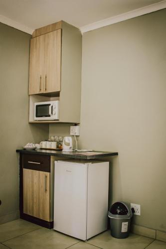 a kitchen with a white refrigerator and a microwave at The Daughters Guest House in Bethlehem
