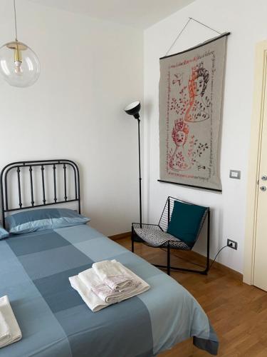 um quarto com uma cama azul e uma cadeira em Bed and Breakfast Gaia em Casamassima