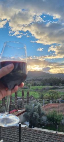 a person holding a glass of wine with a view at Rebetika Hotel & bistro in Selcuk