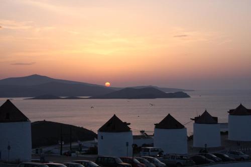 a sunset over the water with a lot of buildings at Kallichoron Art Boutique Hotel in Astypalaia Town
