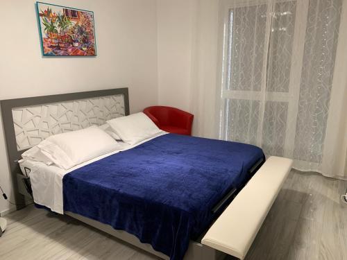 a bedroom with a bed and a red chair at B&B Kelly Plus in Lausanne