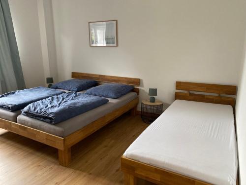 2 camas con almohadas azules en un dormitorio en Ferienhaus Sieglinde mit Deichblick, en Emden