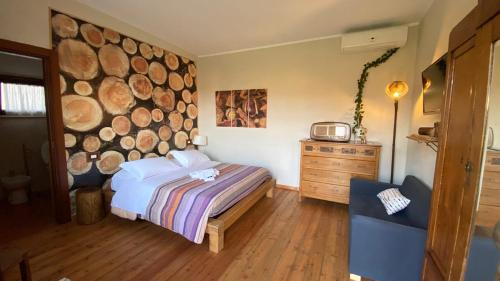 a bedroom with a bed and a large log wall at Agriturismo Quartuccio in Oricola