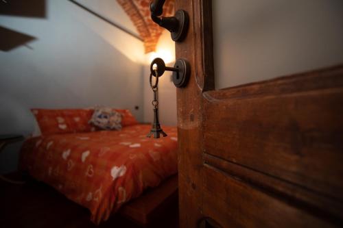 a room with a bed and a door with a lamp at La Locanda del Bistrot dei Vinai in Cuneo