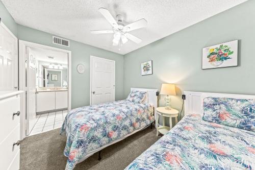 een slaapkamer met 2 bedden en een plafondventilator bij Tradewinds Unit 406 in Orange Beach