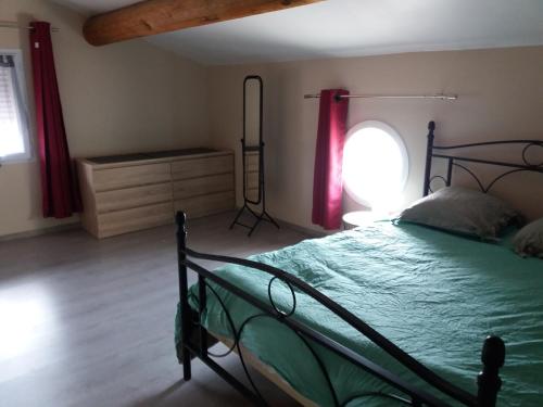 une chambre avec un lit vert et une fenêtre dans l'établissement Villa de vacances, à Saint-Victor-la-Coste