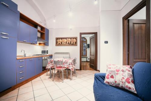 uma cozinha com um sofá azul e uma mesa em La Locanda del Bistrot dei Vinai em Cuneo