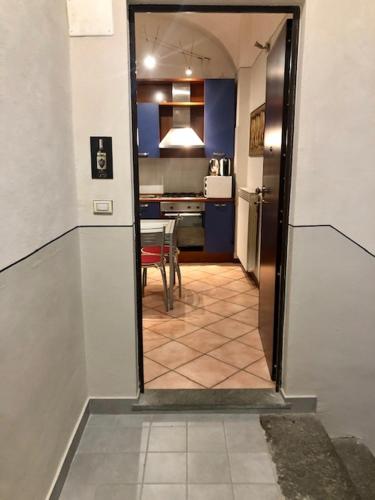 a hallway leading to a kitchen with a table and a room at La Locanda del Bistrot dei Vinai in Cuneo