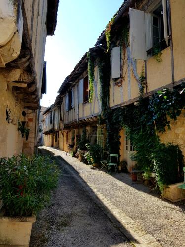 an alley with ivy on the side of a building at NAMASTE COTTAGE in Issigeac
