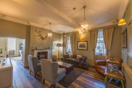 a living room filled with furniture and a fireplace at Kedleston Country House B&B in Derby