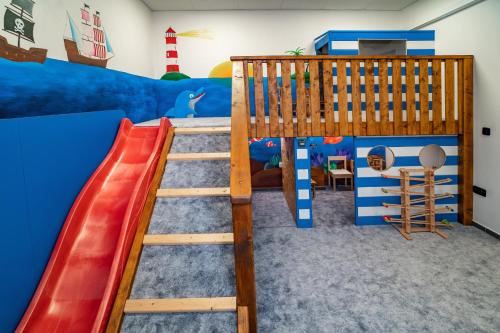 a kids room with a slide and a bunk bed at Hotel Smrž in Sepekov