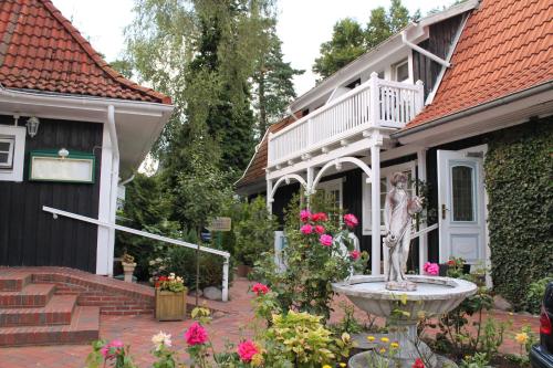 a statue in front of a house with a fountain at Hotel Im Schwedischen Hof in Binz
