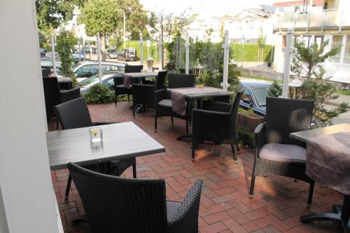 an outdoor patio with tables and chairs and cars at Hotel Im Schwedischen Hof in Binz