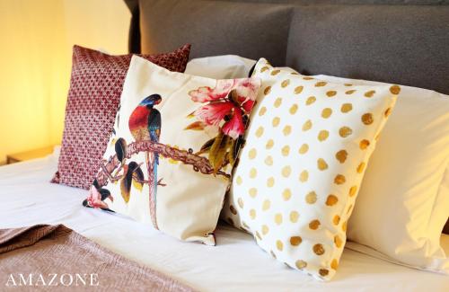 a bed with pillows on it with at MELMA PROPERTIES-AMAZONE-premium apartment in Piraeus center in Piraeus