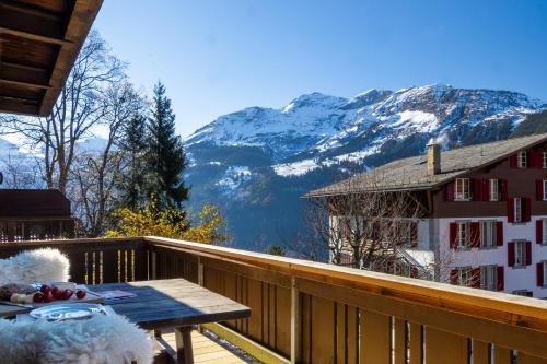 a balcony with a table and a view of a mountain at Chalet Schweizerhof 1 in Wengen