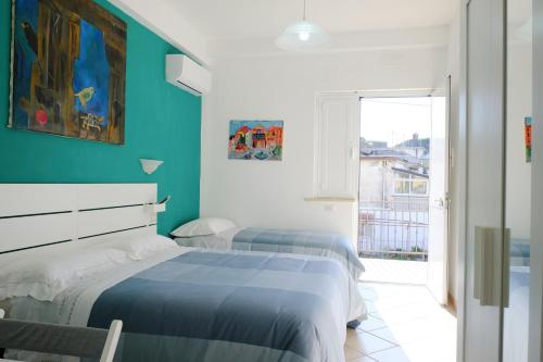 two beds in a room with a blue wall at a casa di Chiara bed and breakfast in Capaccio-Paestum