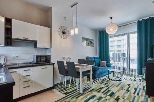 kuchnia i salon ze stołem i kanapą w obiekcie Apartamenty Świnoujście - Aleja Baltic Park Molo C206 w Świnoujściu