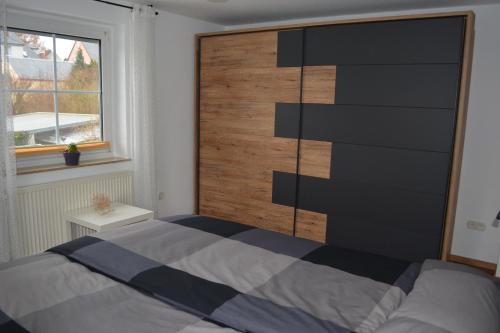 a bedroom with a bed and a wooden wall at Fewo Bauer in Oberkotzau
